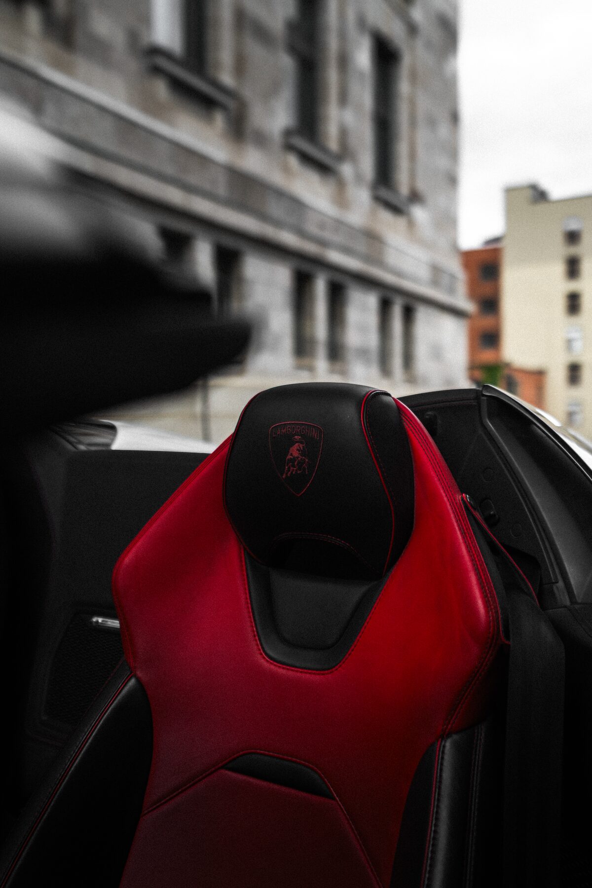 Lamborghini red leather seat against Old Montréal stone architecture