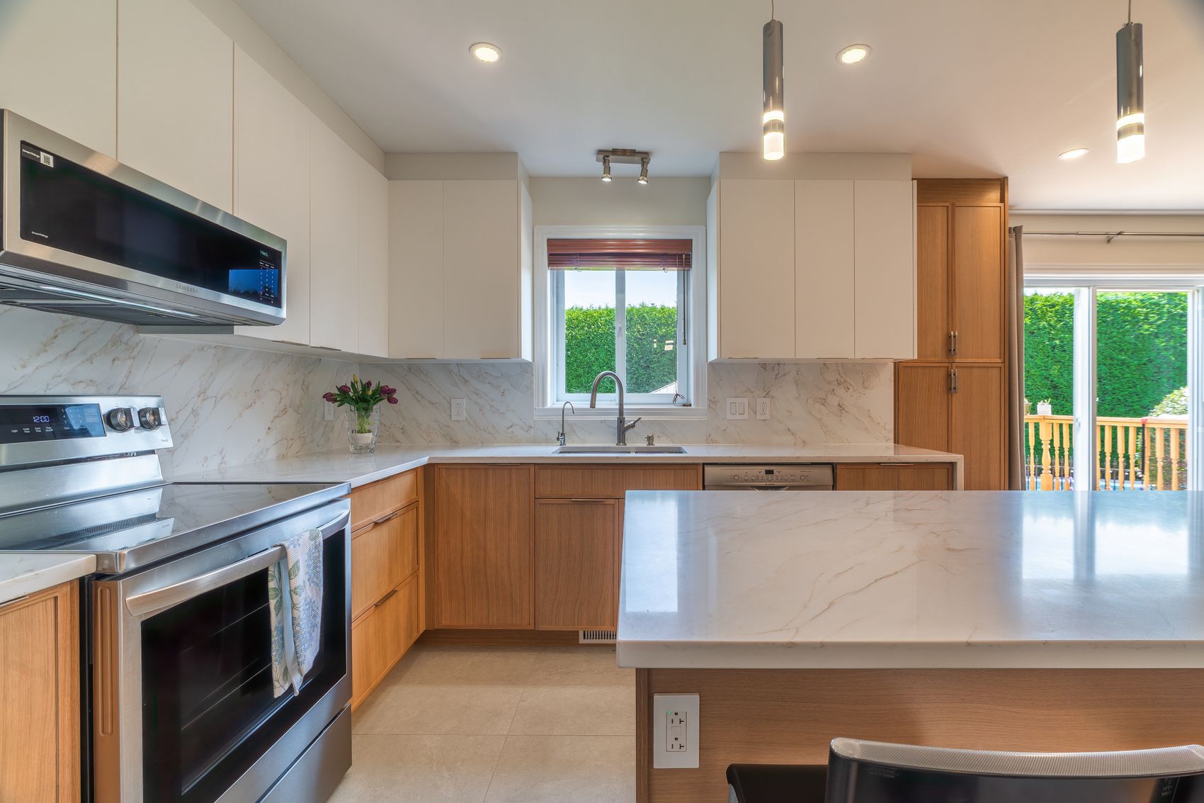 Custom kitchen with quartz island and oak cabinetry — AMH custom home